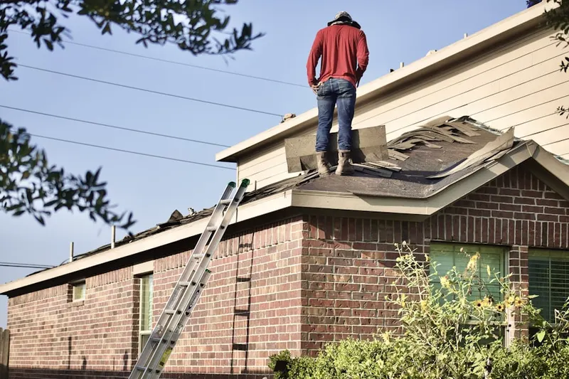 Professional roofer working on a residential roof in Welles Village